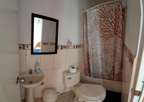 a bathroom with a toilet and a sink and a mirror at Starfish of Paracas in Paracas