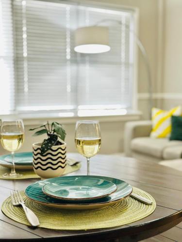 a table with a plate and two glasses of wine at Charming Jax Apt for 4 with free parking in Jacksonville