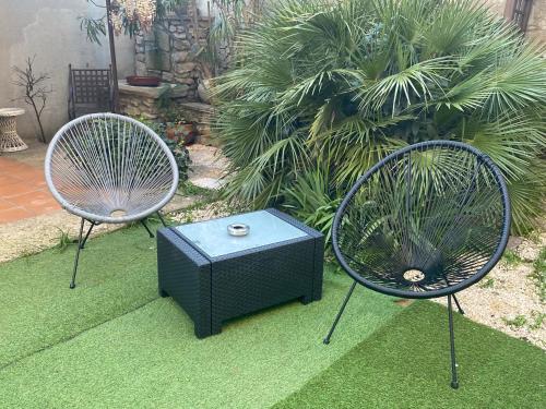 twee stoelen en een televisie zittend op het gras bij Les Lauriers Duplex centre ville avec jardin in Nyons