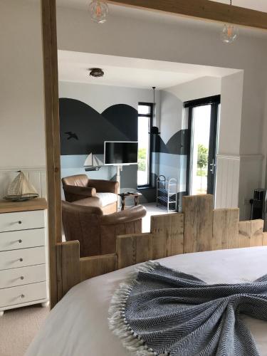 a bedroom with a bed and a living room at Mevagissey Boutique Flatlet with sea and countryside views in Mevagissey