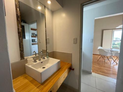 een badkamer met een witte wastafel en een spiegel bij Departamento familiar in Coronel Suárez