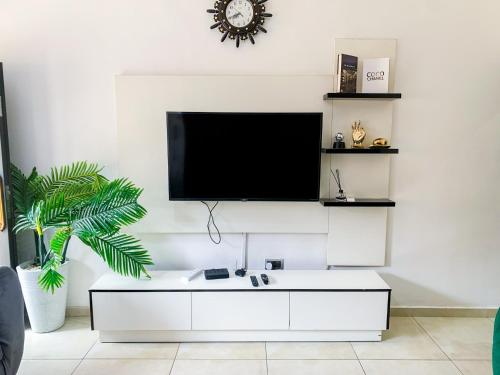 ein Wohnzimmer mit einem TV an einer weißen Wand in der Unterkunft Yardcourt 3Bedroom in Lagos