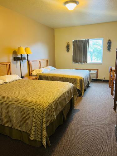a hotel room with two beds and a window at HAWARDEN HARVEST INN in Hawarden