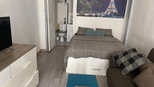une chambre avec un lit, un canapé et une télévision dans l'établissement Le charles, à Paris