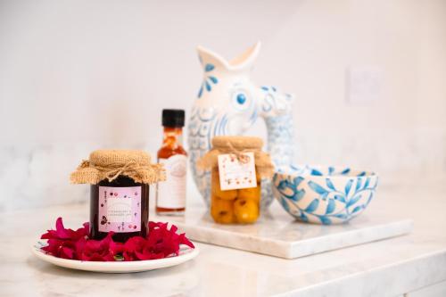 una mesa con un plato de flores y una botella de miel en 'Notabile' - Private Townhouse in Mdina en Mdina