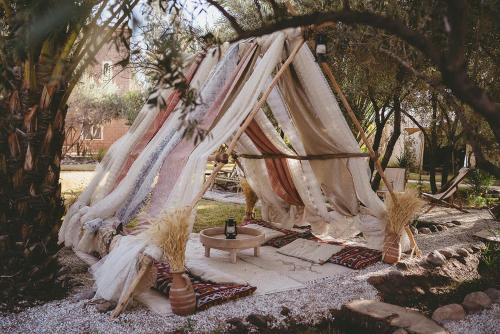 a tent with a table under a tree at L'Ma Lodge in Skoura