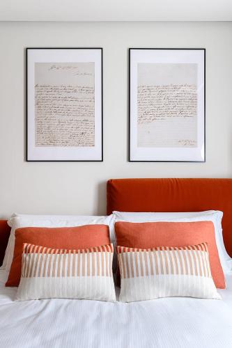 a bedroom with two pillows and two pictures on the wall at GL HOME in Como