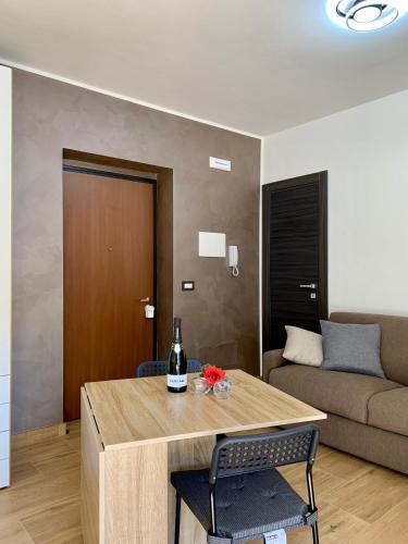 a living room with a table with a bottle of wine at Griseo - Sicily Vista in Calatabiano