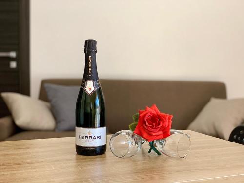 a bottle of wine sitting on a table with a rose at Griseo - Sicily Vista in Calatabiano