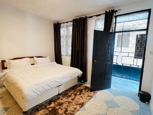 a bedroom with a bed and a large window at Urban Haven Rooms in Iringa