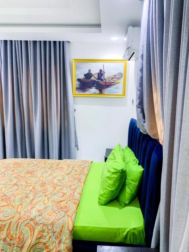 1 dormitorio con 1 cama con reposapiés verde en 60B Adetoun Adelaja 4Bedroom, en Lagos