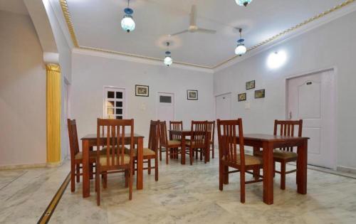a dining room with a table and wooden chairs at Boho Heritage Stays Udaipur in Udaipur
