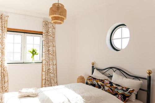 1 dormitorio con cama y espejo en Johnny's Casa, en Vila do Bispo