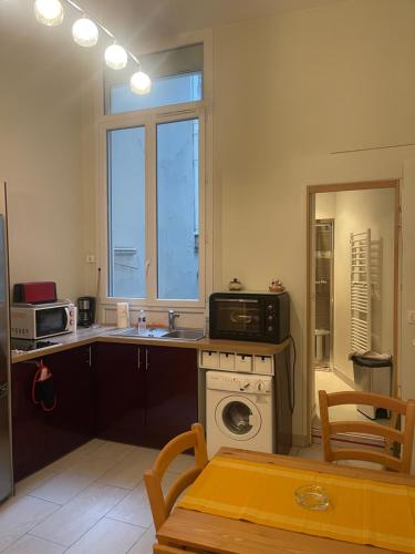 une cuisine avec un évier et une machine à laver dans l'établissement 巴黎圣母院单间公寓, à Paris