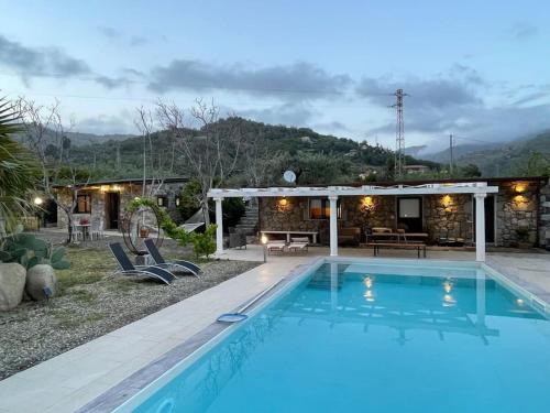 a swimming pool in front of a house at Sicily Stone Cottage in Graniti