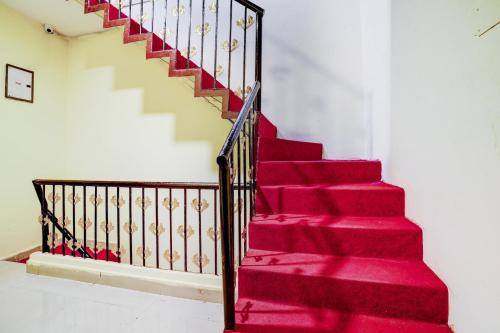 una escalera de moqueta roja con alfombra roja en OYO Imperial Guest House, en Hyderabad