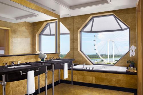 a bathroom with two sinks and a large window with a large wheel at The Ritz-Carlton, Millenia Singapore in Singapore