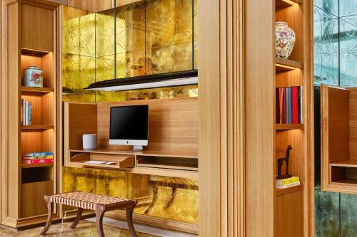 a living room with a tv and a bench in a room at The Ritz-Carlton, Millenia Singapore in Singapore