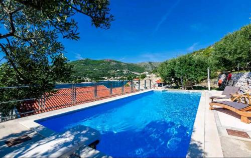 a large swimming pool with blue water at Villa Matej with pool and sea view in Zaton