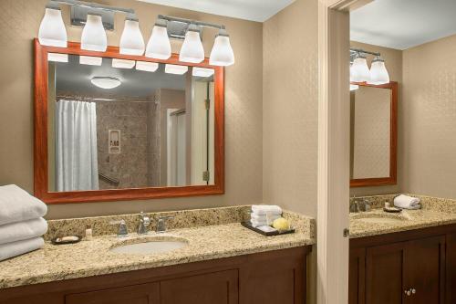a bathroom with a sink and a mirror at Sheraton Suites Akron Cuyahoga Falls in Cuyahoga Falls