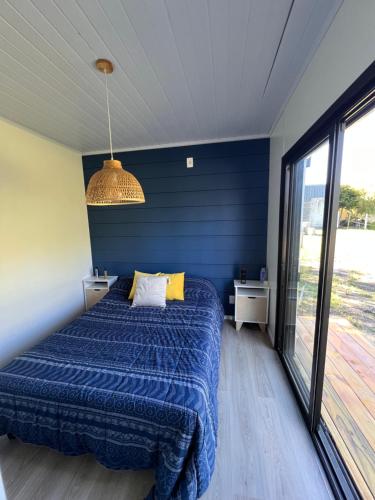1 dormitorio con cama y pared azul en Alojamiento en playa fomento en Fomento