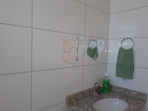 a bathroom with a sink and hearts on the wall at Apartamento do Remanso 2/4 in Hortolândia