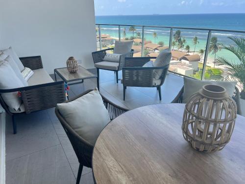 a balcony with tables and chairs and a view of the beach at Delux Oceanview on the Caribbean @ Playa Escondida Resort in María Chiquita