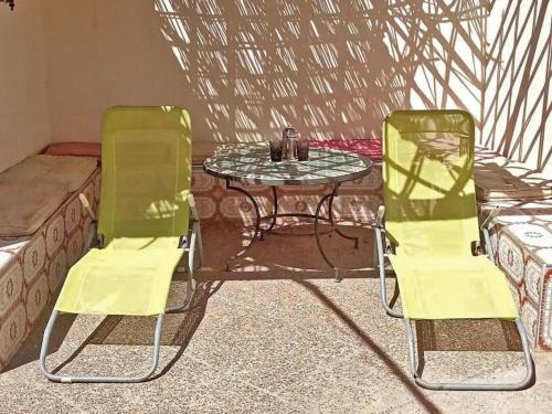2 sillas amarillas, mesa, mesa y sofá en Maison du Fleurs, en Taroudant