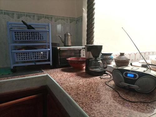 a kitchen with a counter with a microwave and a blender at Maison du Fleurs in Taroudant