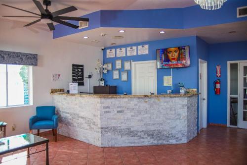 a bar in a restaurant with a blue wall at Playa Inn Rocky Point in Puerto Peñasco