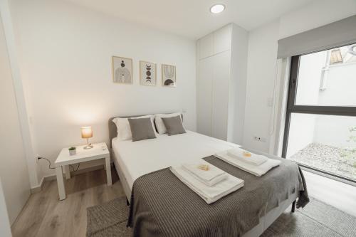 a white bedroom with a bed and a window at Amazing Villa by Hosty in Porto