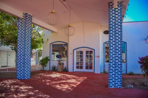 a house with blue pillars and a door with a window at Playa Inn Rocky Point in Puerto Peñasco