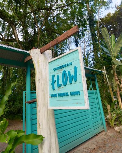 a sign on a tree next to a blue shed at Caribbean Flow in Puerto Viejo