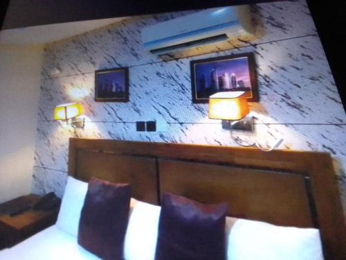 a bedroom with a stone wall with two lights above a bed at Villa toscana Victoria island oniru in Lagos