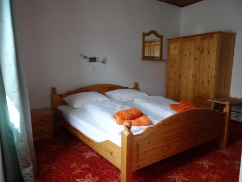 a bedroom with a wooden bed with two orange pillows at Schlummerburg in Weißkirchen in Steiermark