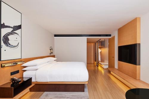 a bedroom with a bed and a flat screen tv at Fairfield by Marriott Guangzhou Konggang in Guangzhou