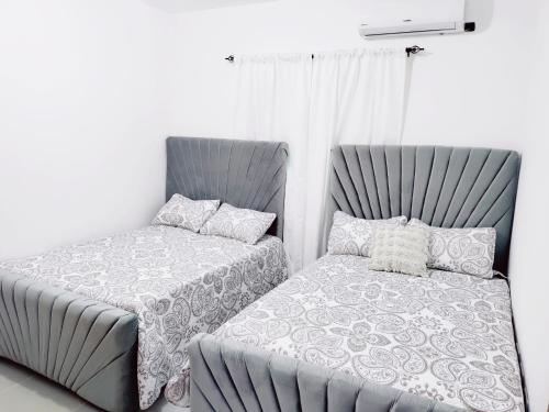 Duas camas sentadas uma ao lado da outra num quarto em Confortable Apartamento con Piscina en Cabrera em Cabrera