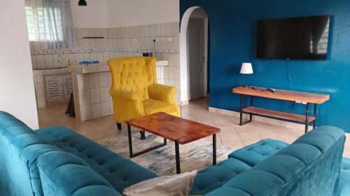 een woonkamer met een blauwe bank en een tafel bij Bedroom Diani Beach in Diani Beach