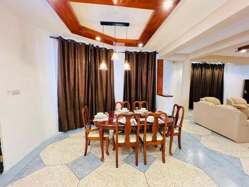 jadalnia ze stołem, krzesłami i kanapą w obiekcie Urban Haven Rooms w Irindze