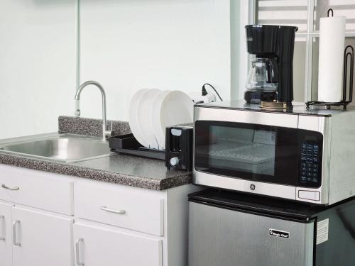 La cuisine est équipée d'un four micro-ondes et d'un évier. dans l'établissement PERLA in Carolina PR 11 Min From Airport, à Carolina