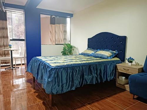a bedroom with a bed with a blue headboard at Munay Wasi CUSCO in Cusco