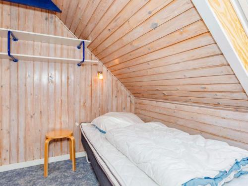 a bed in a room with a wooden wall at 9 person holiday home in Thyholm-By Traum in Thyholm