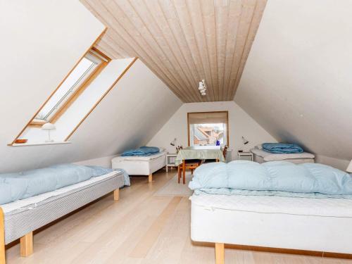 a attic room with two beds and a table at Holiday home Vestervig XLIX in Vestervig