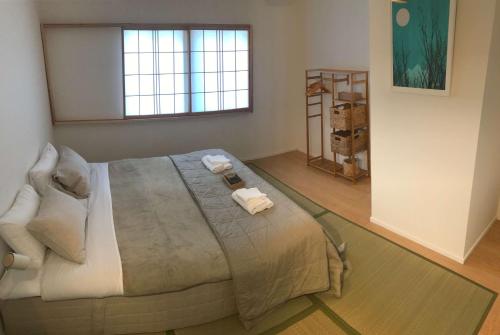 - une chambre avec un grand lit et des serviettes dans l'établissement Myoko Forest Lodge, à Myōkō