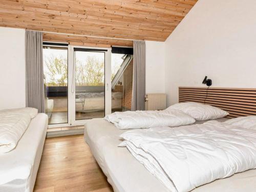 a bedroom with two beds and a large window at 20 person holiday home in Karby-By Traum in Karby