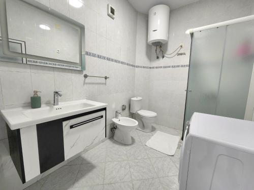 uma casa de banho branca com um lavatório e um WC em Rustic City Center Vibes em Tirana