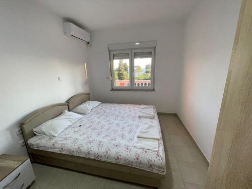 Dormitorio pequeño con cama y ventana en Benelux Apartments en Brca