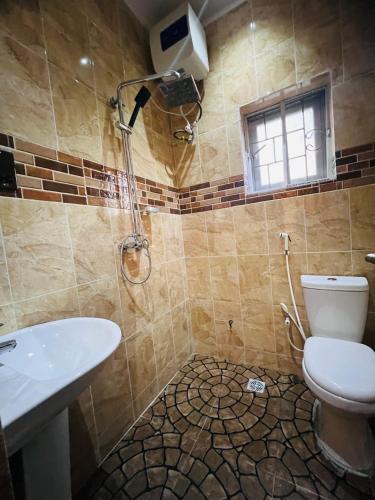 uma casa de banho com um WC, um chuveiro e um lavatório. em Apartments by Dee em Port Harcourt