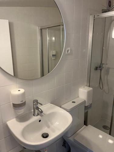 a bathroom with a sink and a toilet and a mirror at Bairro Alto - Apartamento in Lisbon