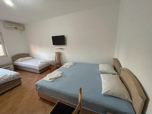 Habitación con 2 camas y TV en la pared. en Benelux Apartments en Brca
